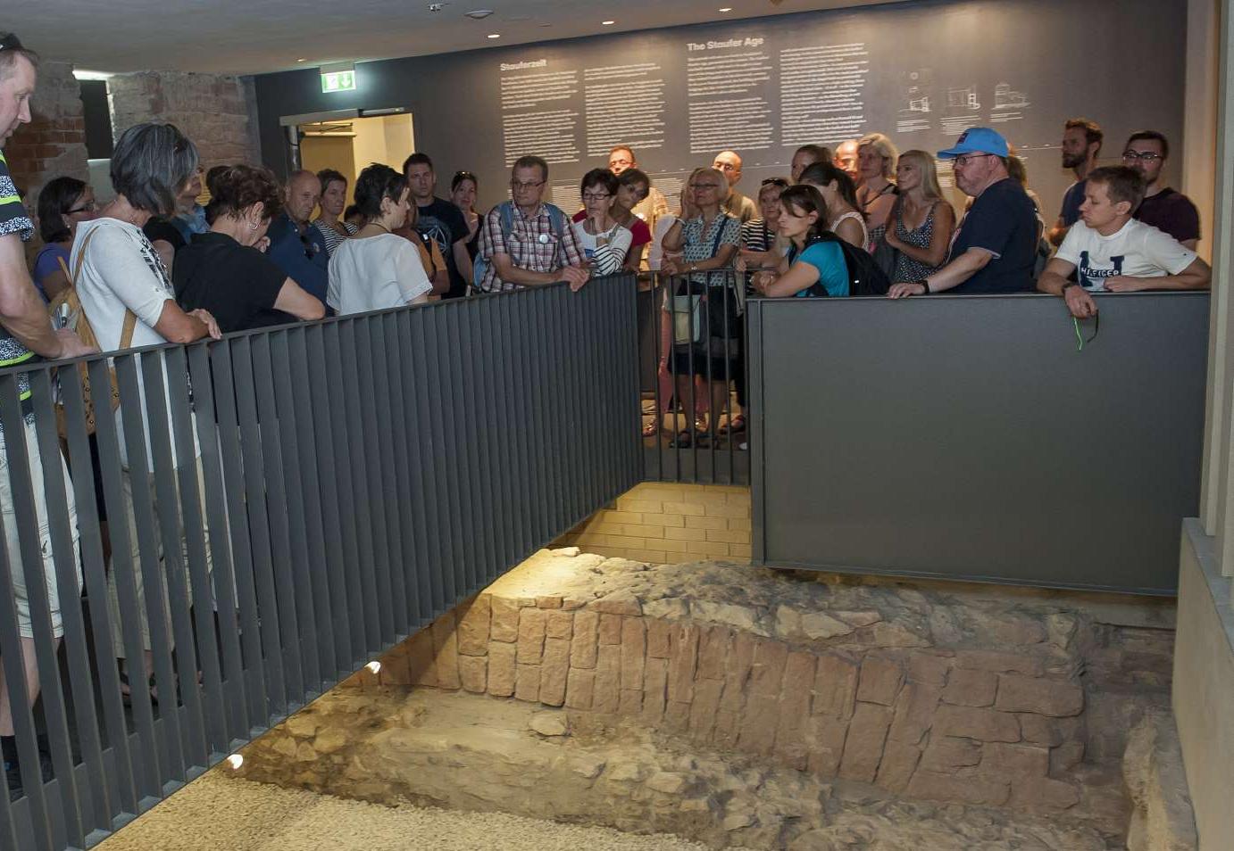 Besucher des Museums betrachten alte Grundmauern des Saalhofs