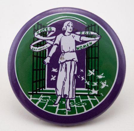 Das Foto zeigt einen grün/lila Anstecker der Frauenstimmrechtsbewegung