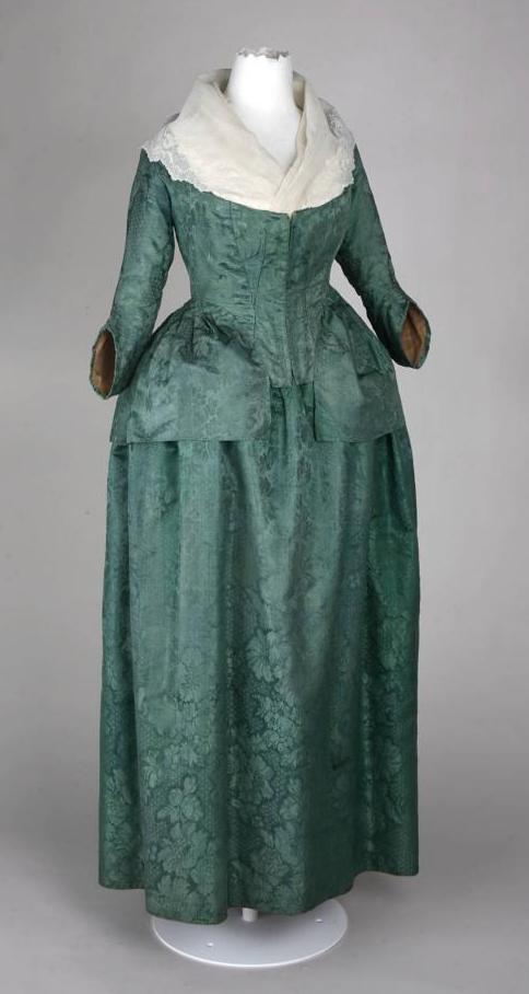 Das Foto zeigt ein grünes Damenkostüm, bestehend aus Casaquin (Schoßjacke) und Rock um 1780
